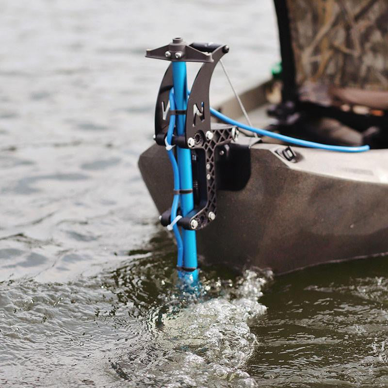 Close-up of a Bixpy Jet electric motor mounted on a blue vertical pole at the stern of a kayak, propelling through rippled water and creating a wake.