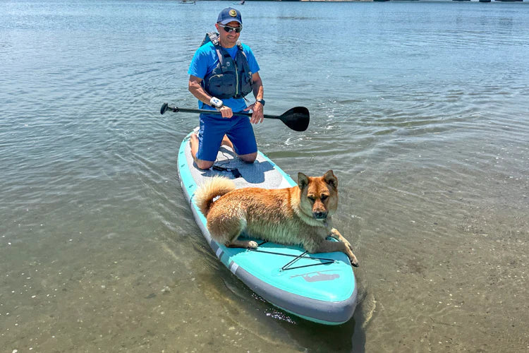 Man on Atoll paddle board with dog as it is motorized by a Bixpy Canada Motor