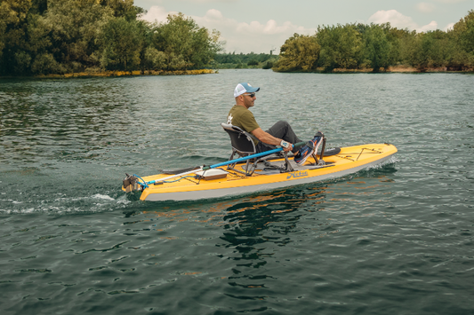 yellow kayak with bixpy k-1 outboard kit mounted with versa rudder on a lake