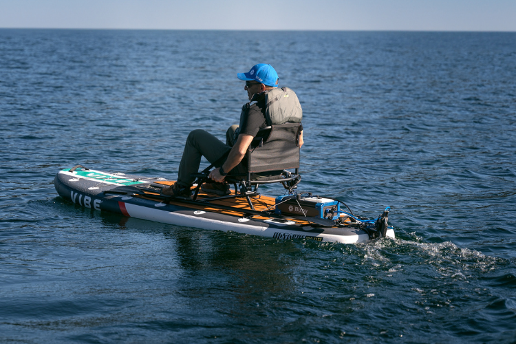 Man on paddleboard using trolling motor for his personal watercraft from Bixpy Canada