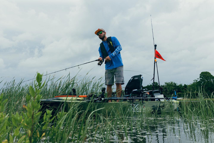 Man fishes from kayak with the Bixpy Canada K-1 attached