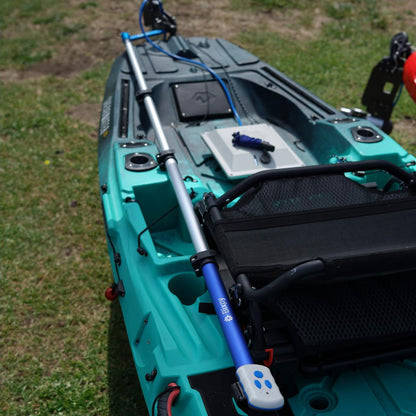 Bixpy Pole Steering™ system installed on a teal fishing kayak, featuring a long aluminum steering pole with a blue Bixpy handle mounted beside the seat, connected to the motor at the stern.