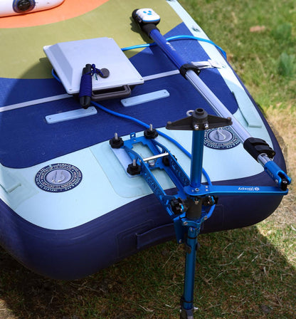Bixpy Pole Steering™ system mounted on an inflatable watercraft, featuring a blue aluminum steering arm connected to a telescoping handle and motor mount, with control cables and hardware secured on the deck.