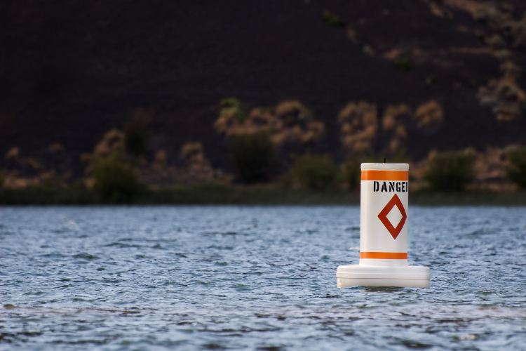 White and yellow buoy with the word danger and a red diamond