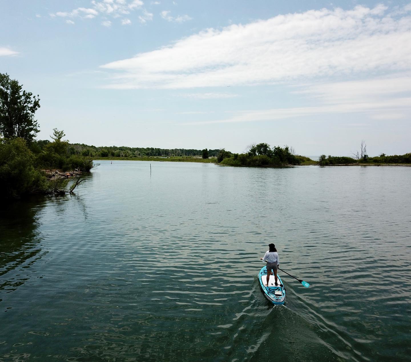 Person stands on paddleboard while Bixpy motor propels them