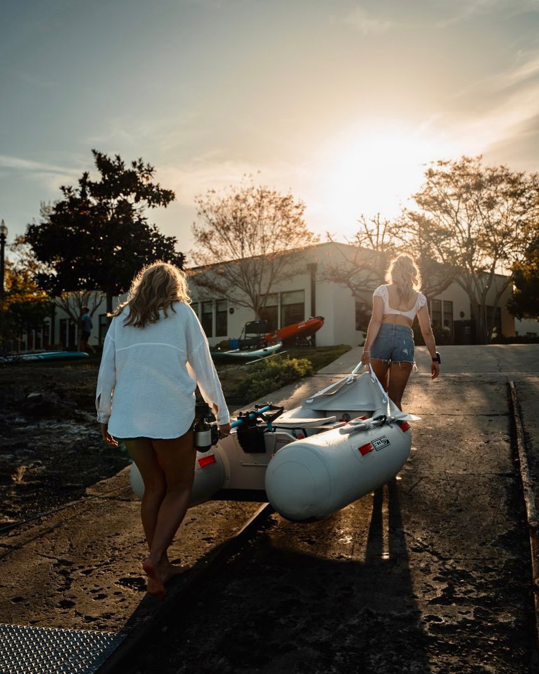 Two women carry inflatable boat with a Bixpy Motor