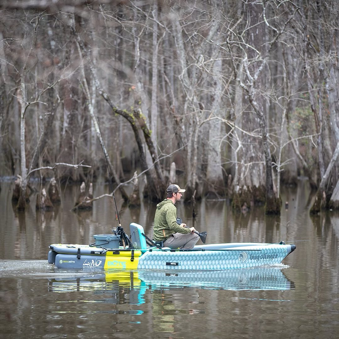 Man motoring in a kayak in the winter