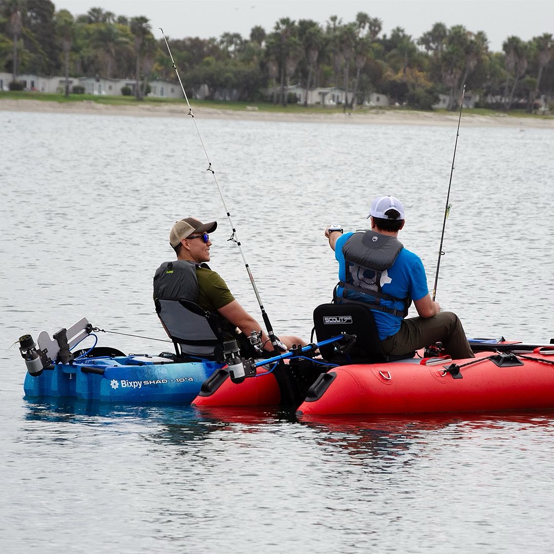 Two men in kayaks with motors wearing Bixpy hats